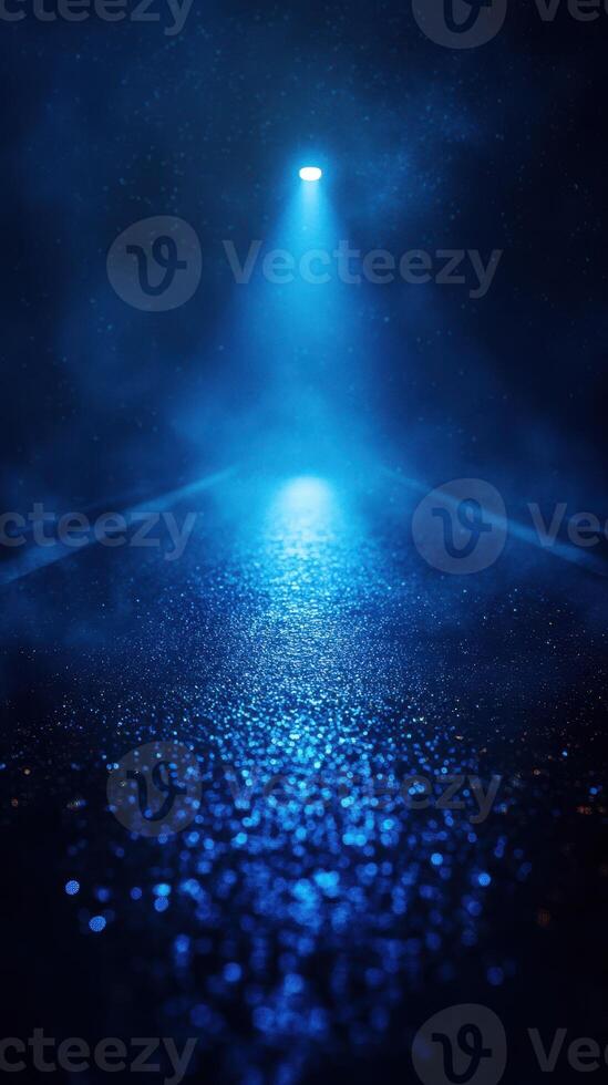 Mysterious blue light illuminating a wet road at night with fog hovering in the atmosphere photo