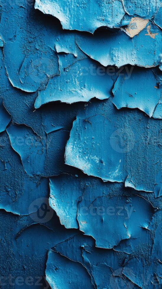 Peeling blue paint on a textured wall creates a captivating display of layered color and decay photo