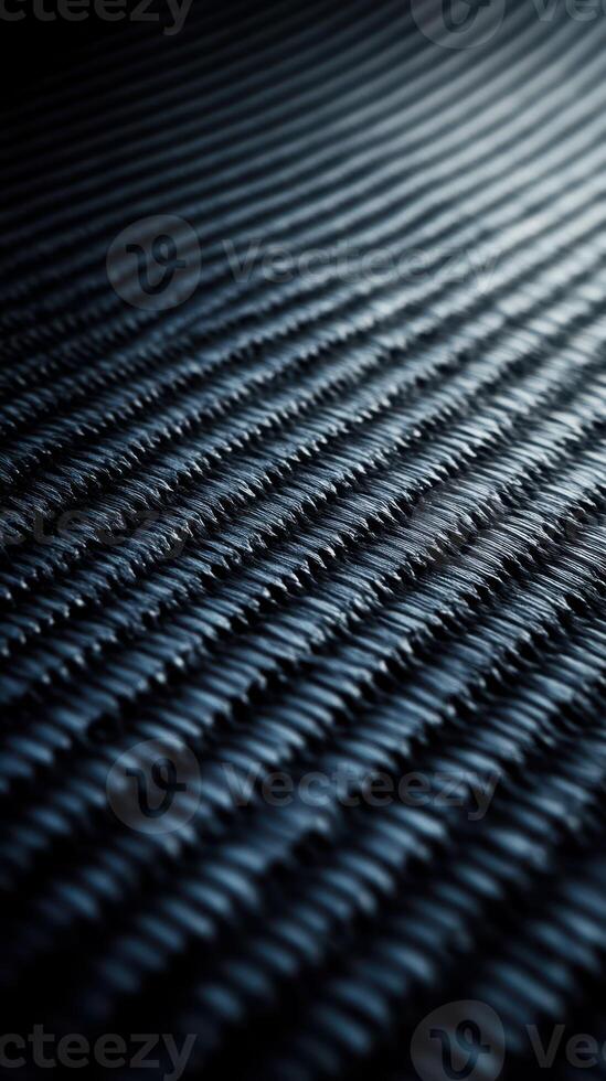Dark textured surface of woven material captures subtle light patterns during an artistic display of shadows and depth photo