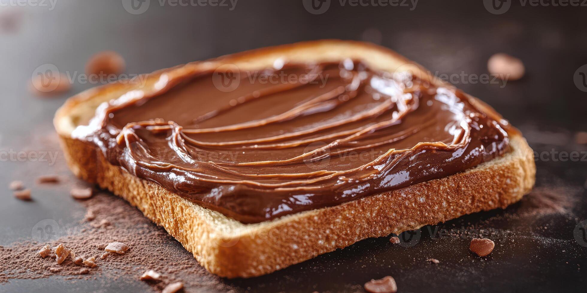 Toast topped with creamy chocolate spread and chocolate shavings on a dark surface photo