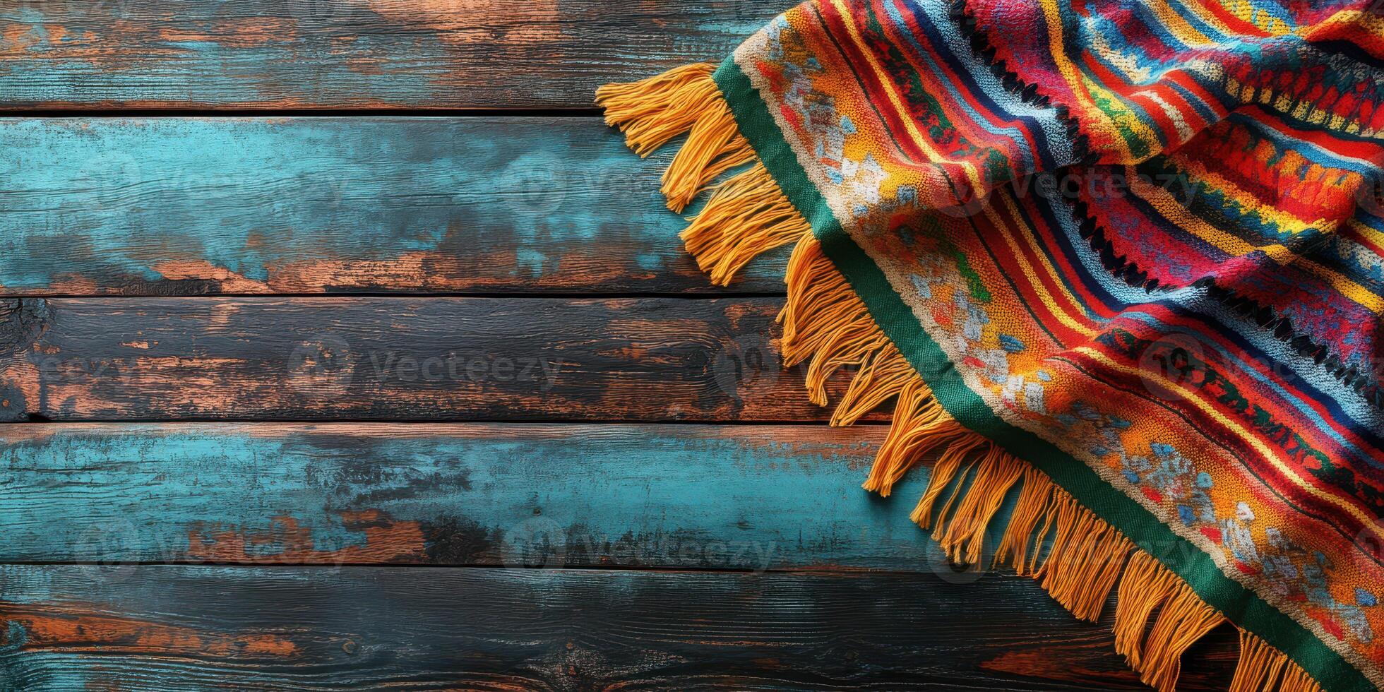 Colorful woven blanket draped over rustic wooden surface featuring bright hues and intricate patterns photo