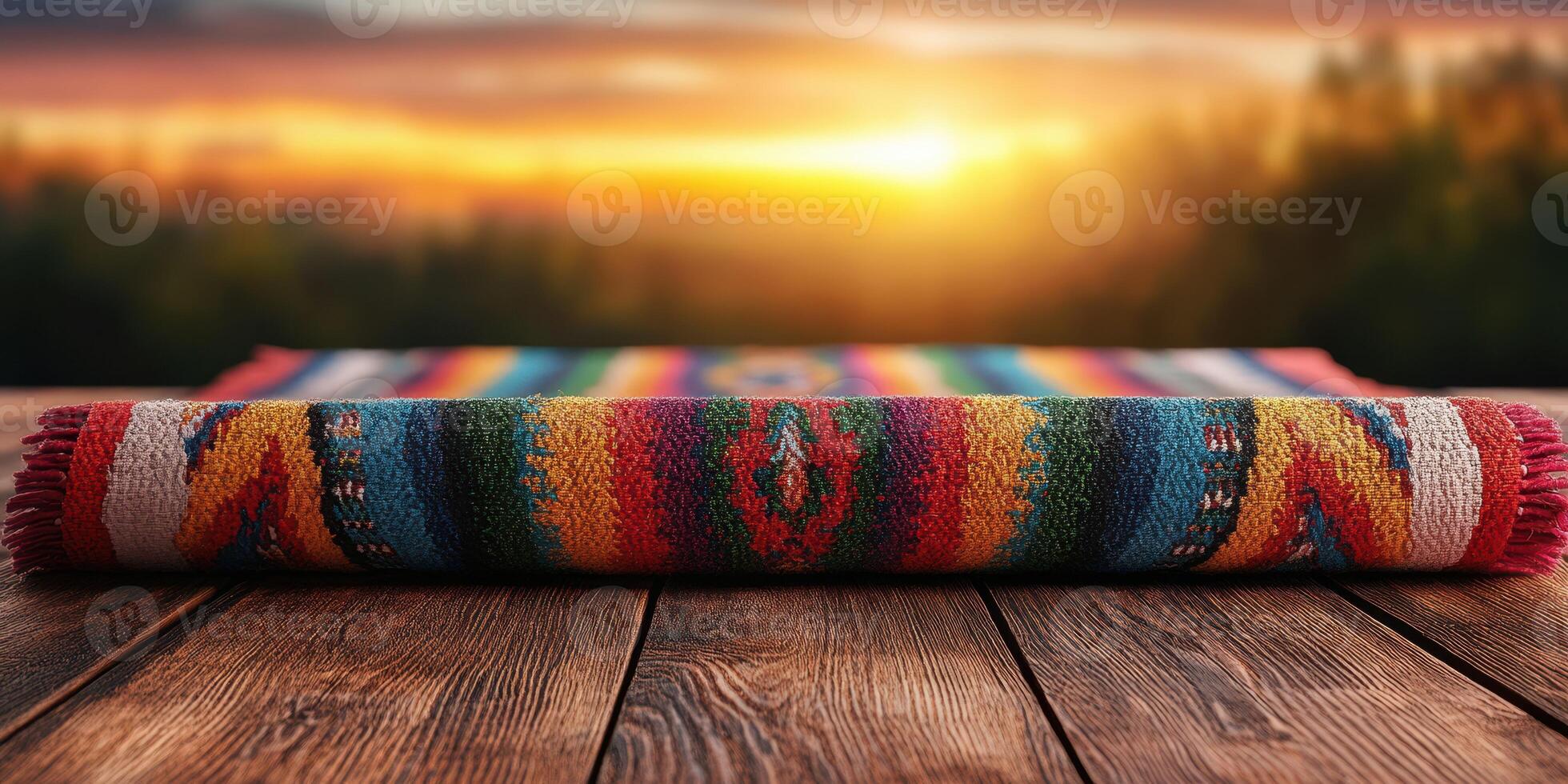 Vibrant woven rug displayed on wooden surface with sunset landscape in the background photo