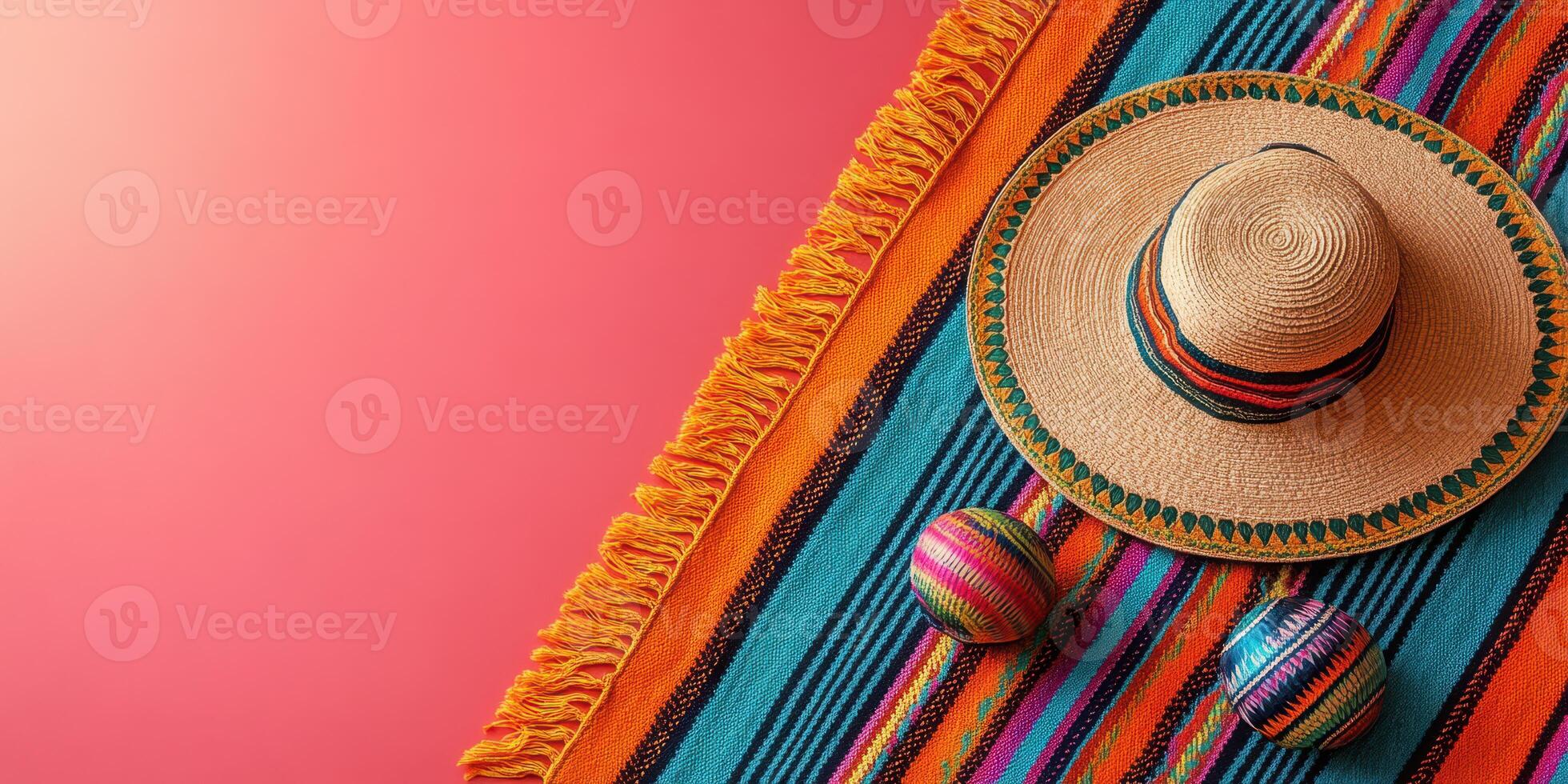 Colorful handcrafted sombrero and decorative balls on vibrant woven blanket placed on bright background, showcasing traditional craftsmanship photo