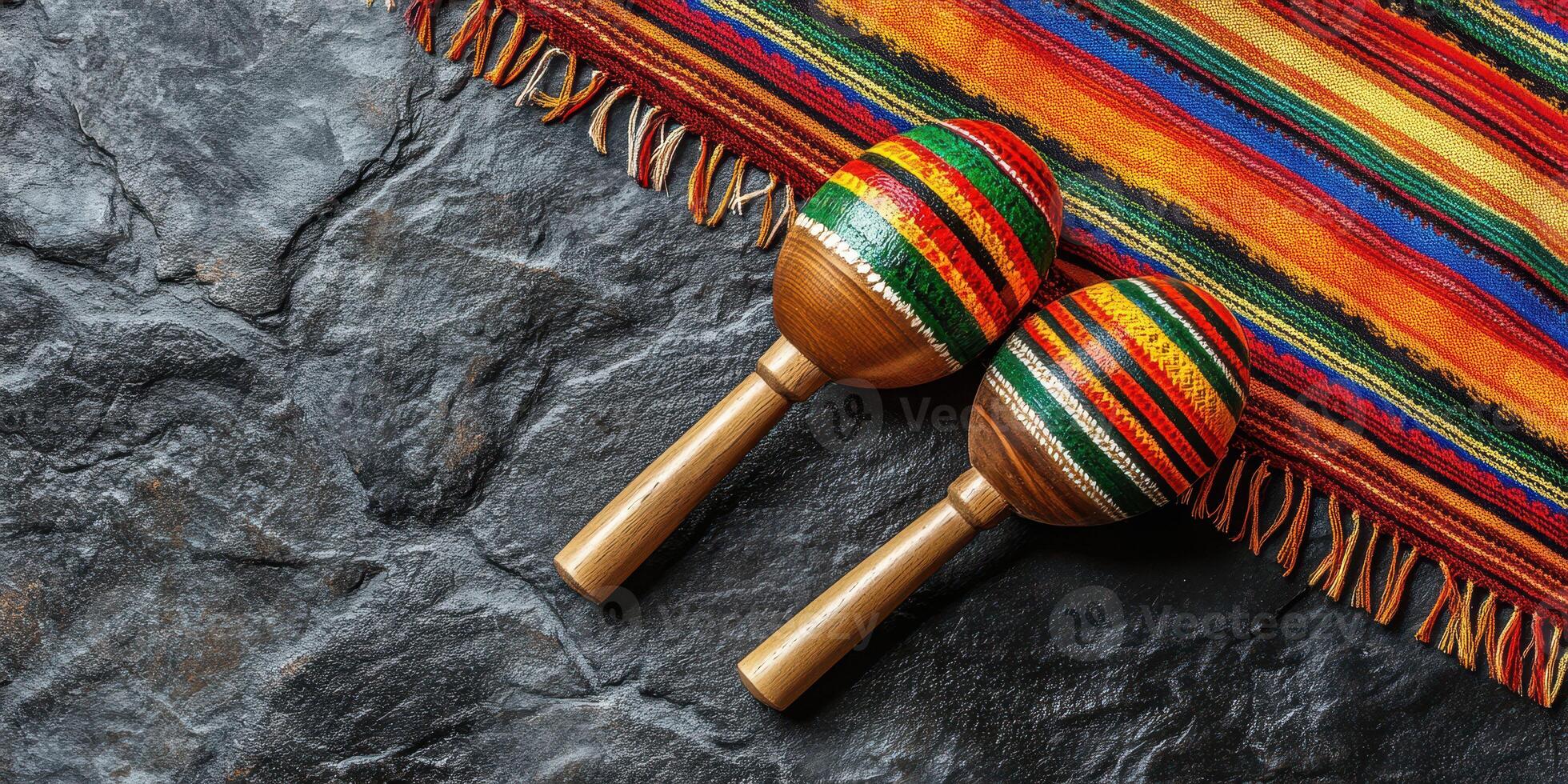 Colorful maracas on a traditional woven blanket arranged on a textured stone surface photo