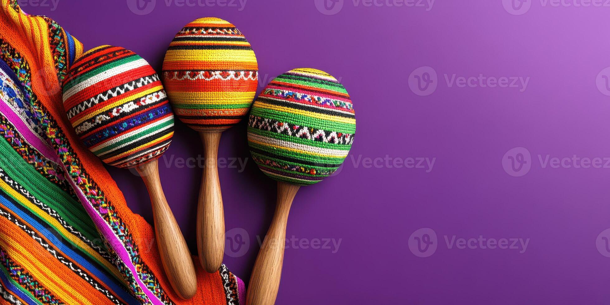 Colorful handmade maracas and traditional fabric displayed on a vibrant purple background during a cultural celebration photo