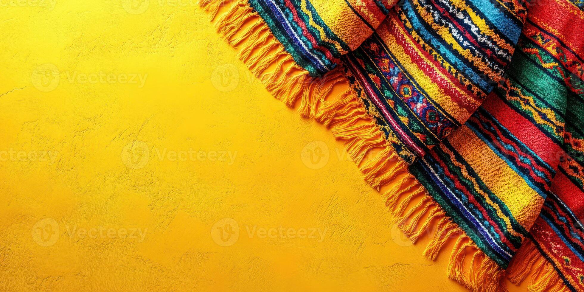 Colorful woven textile draped on vibrant yellow background in a warm indoor setting photo