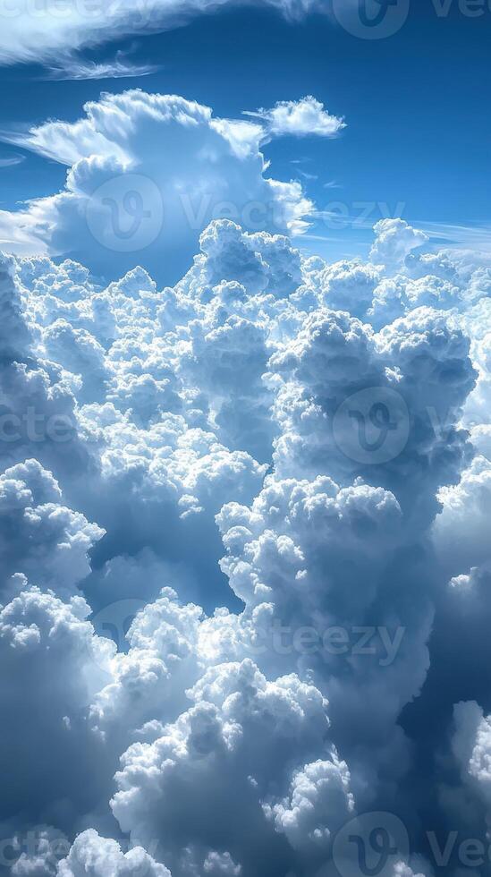 Fluffy white clouds blanket the sky on a bright sunny day with a hint of blue peeking through photo