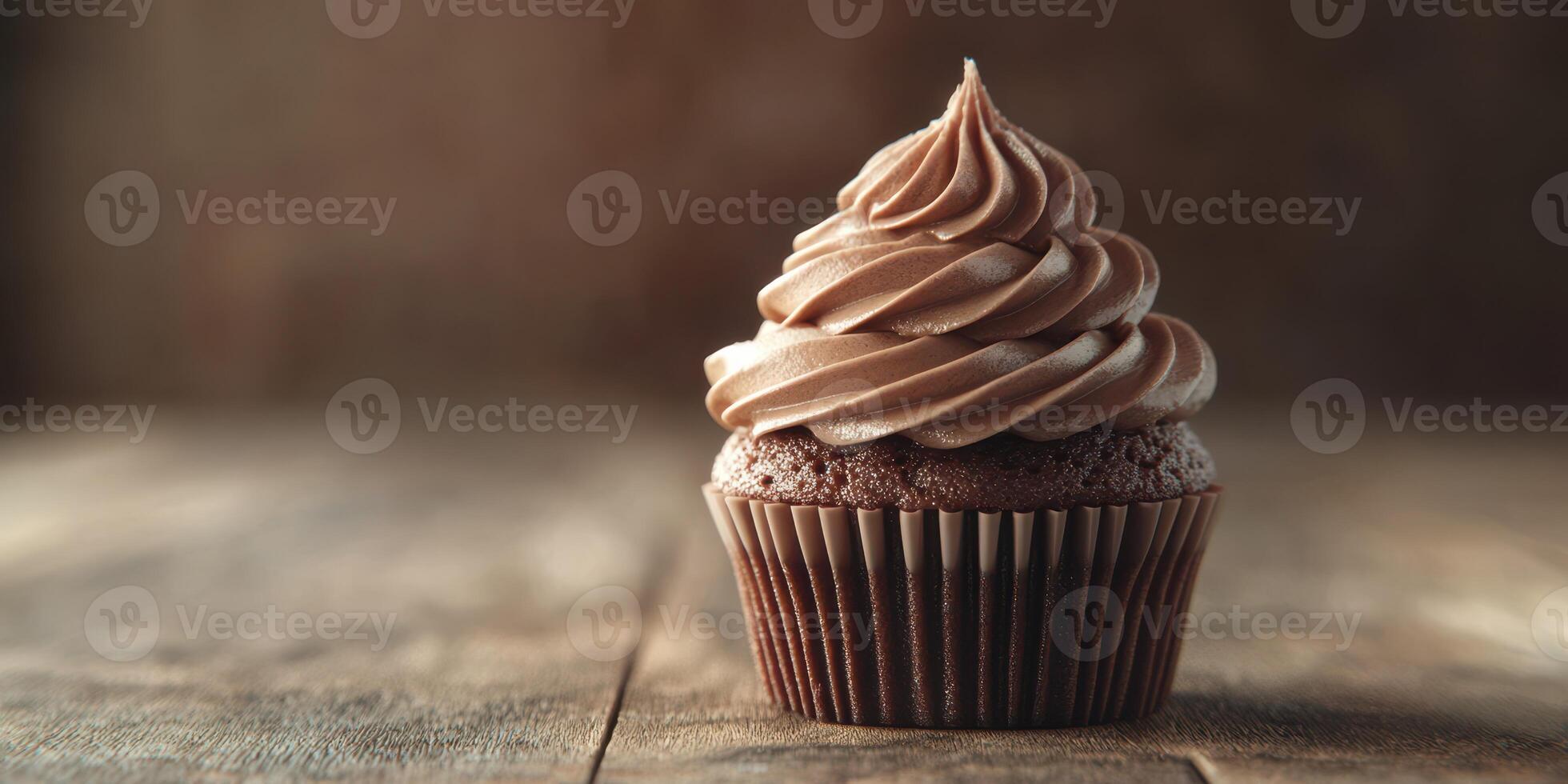 Delicious chocolate cupcake with swirled frosting on wooden table photo