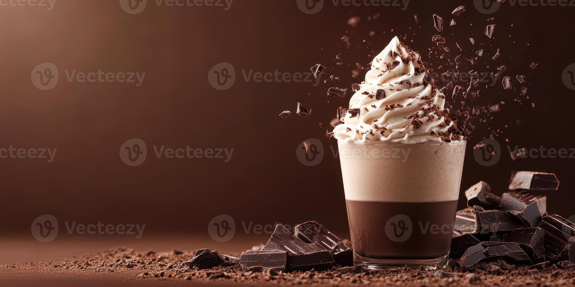 Whipped cream topped dessert with chocolate shavings served in a clear glass on a dark chocolate background photo