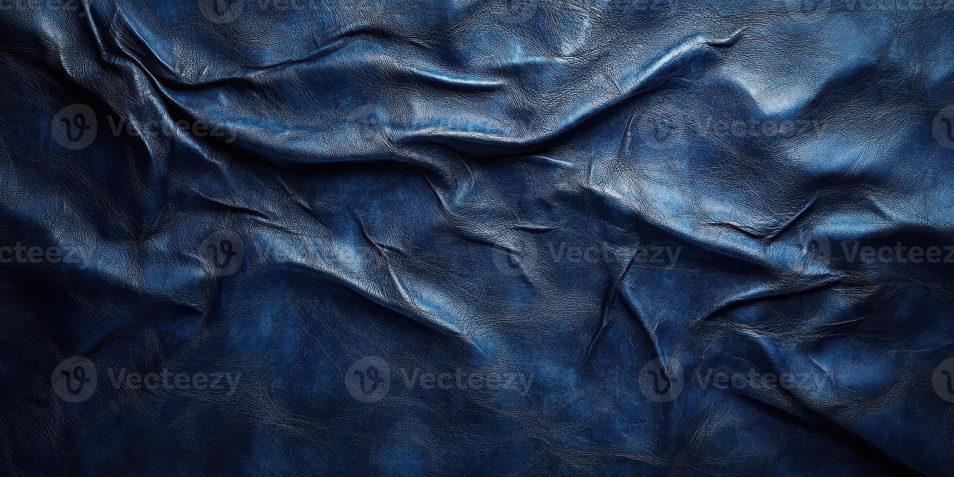 Detailed view of textured dark blue leather showcasing creases and natural patterns in a dramatic light photo