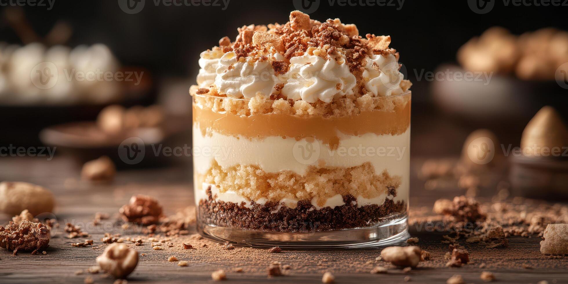 Delicious layered dessert with whipped cream and caramel served in a glass on a rustic wooden table photo