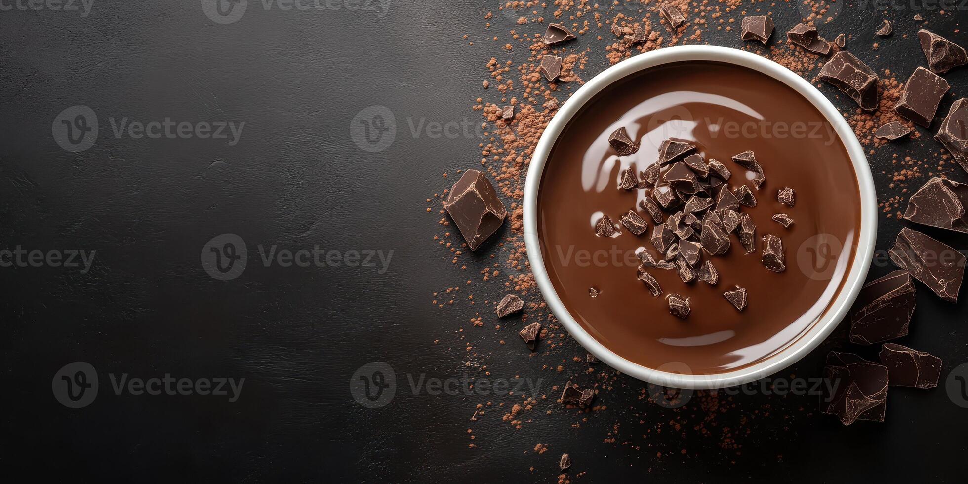 Rich dark chocolate in a bowl with chocolate pieces scattered on a black surface, perfect for desserts or baking activities photo
