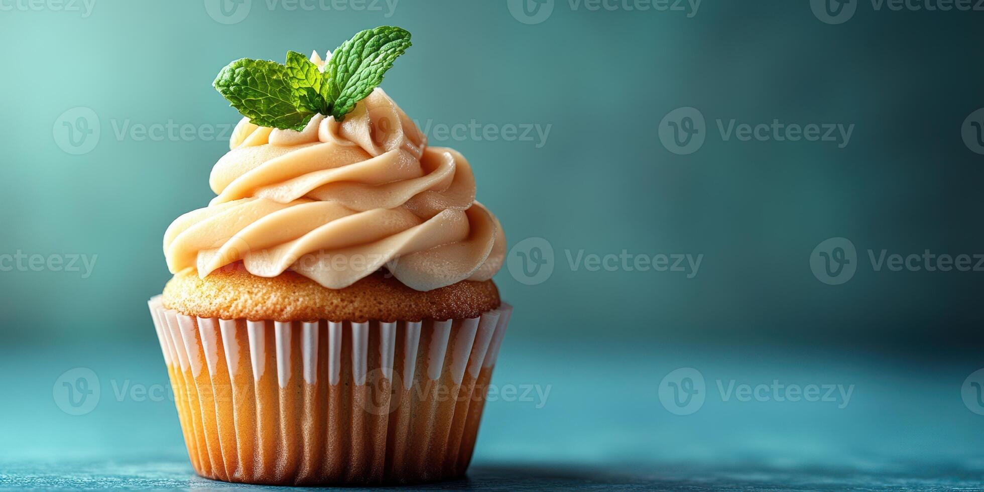 Delicious cupcake topped with creamy frosting and mint leaf on a blue background in a cozy setting photo