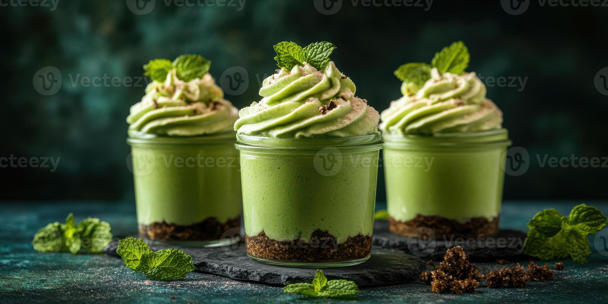 Delicious mint chocolate mousse served in elegant glass jars with chocolate crust and mint leaves photo