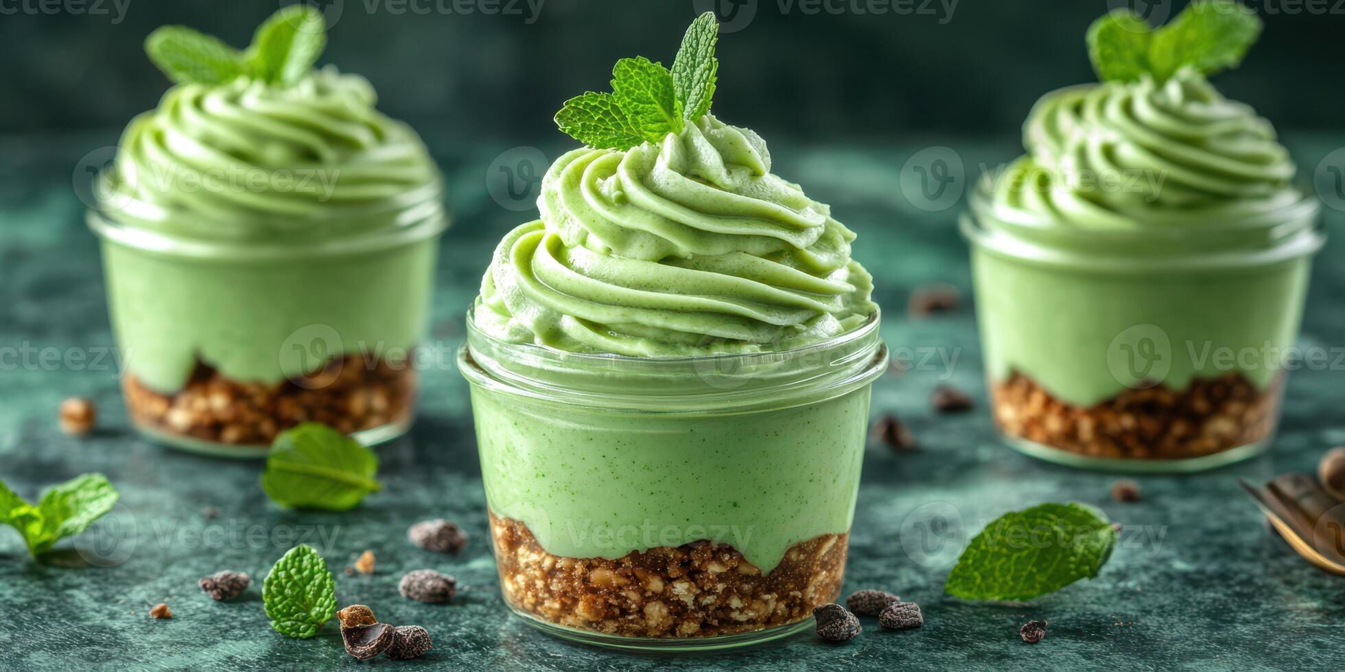 Delicious mint dessert in cups garnished with fresh mint leaves on a green textured background photo
