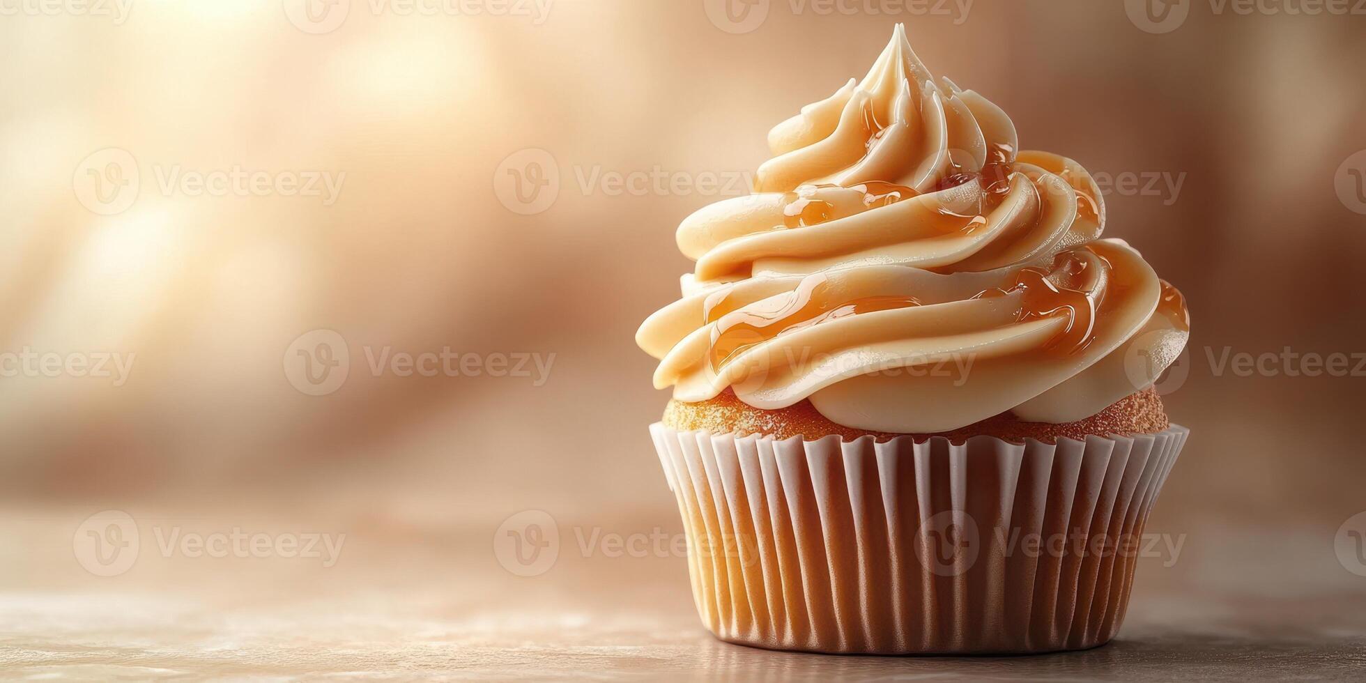 Cupcake with creamy frosting and drizzle on a textured surface in warm lighting photo