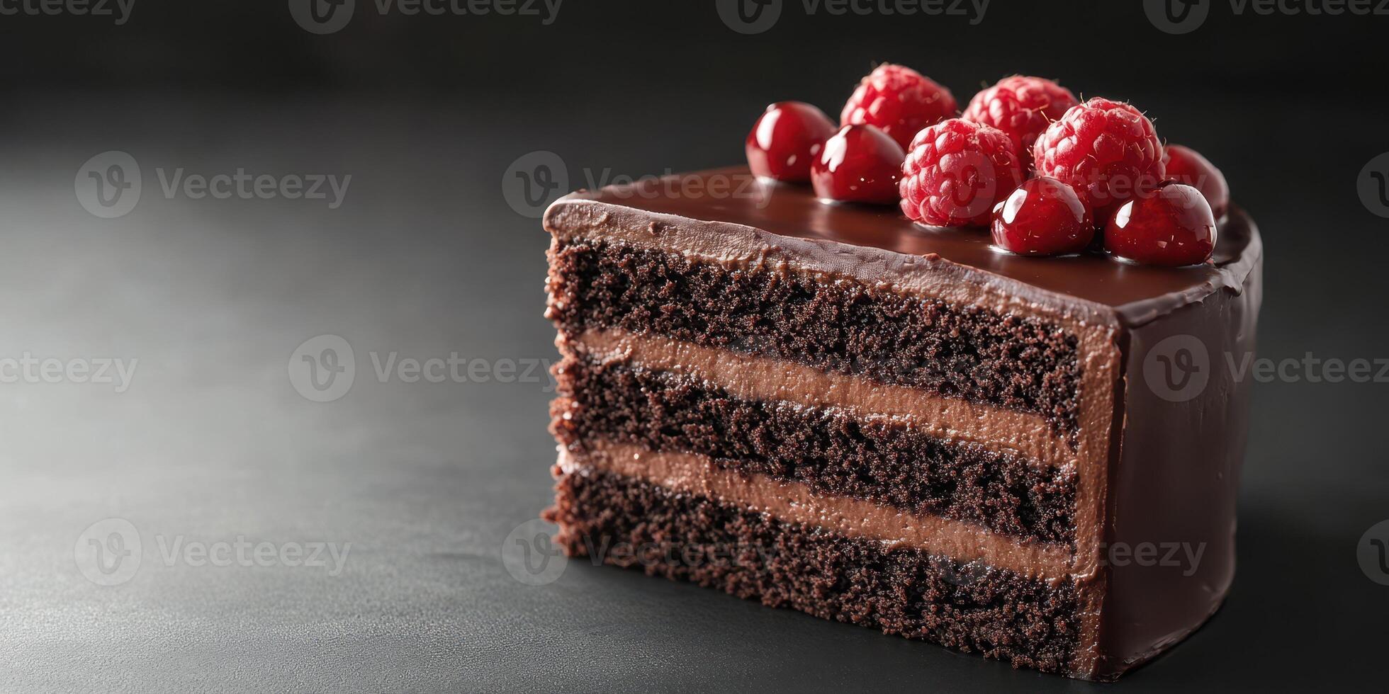 Decadent chocolate cake layered with rich frosting and topped with fresh raspberries on a dark background photo