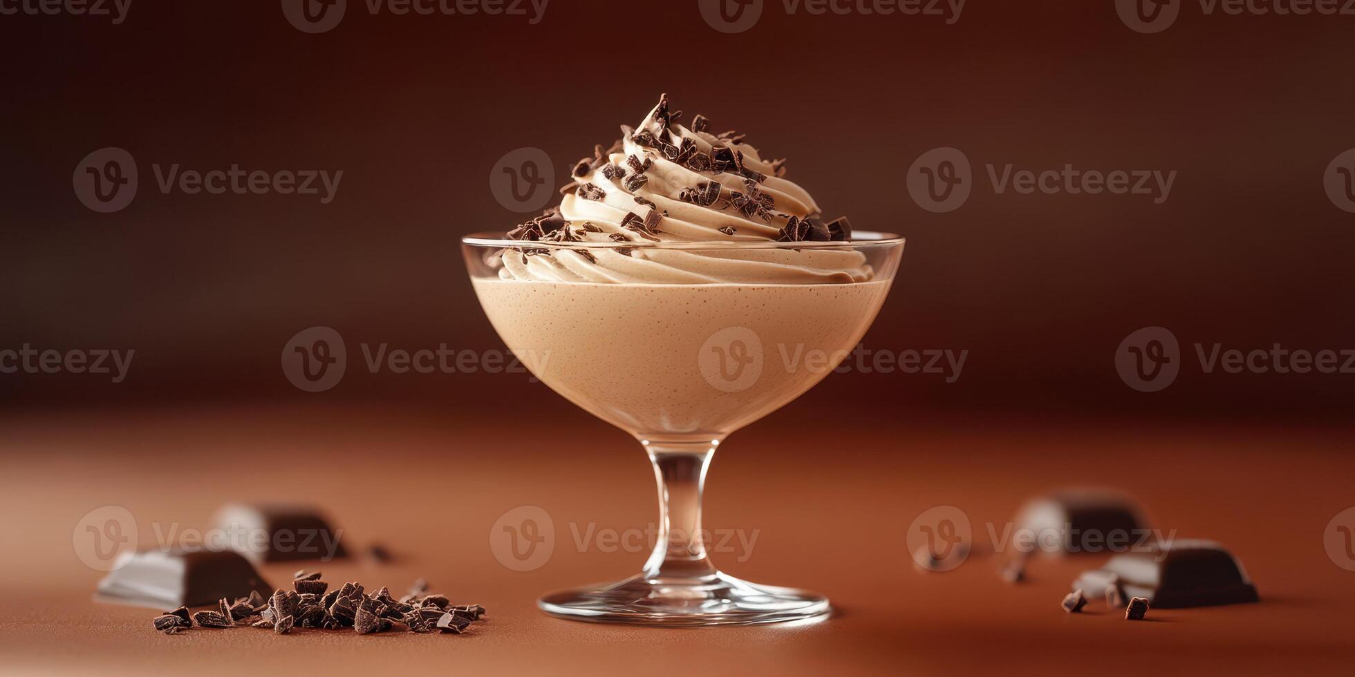 Delicious chocolate mousse topped with whipped cream and chocolate shavings served in a glass dish photo