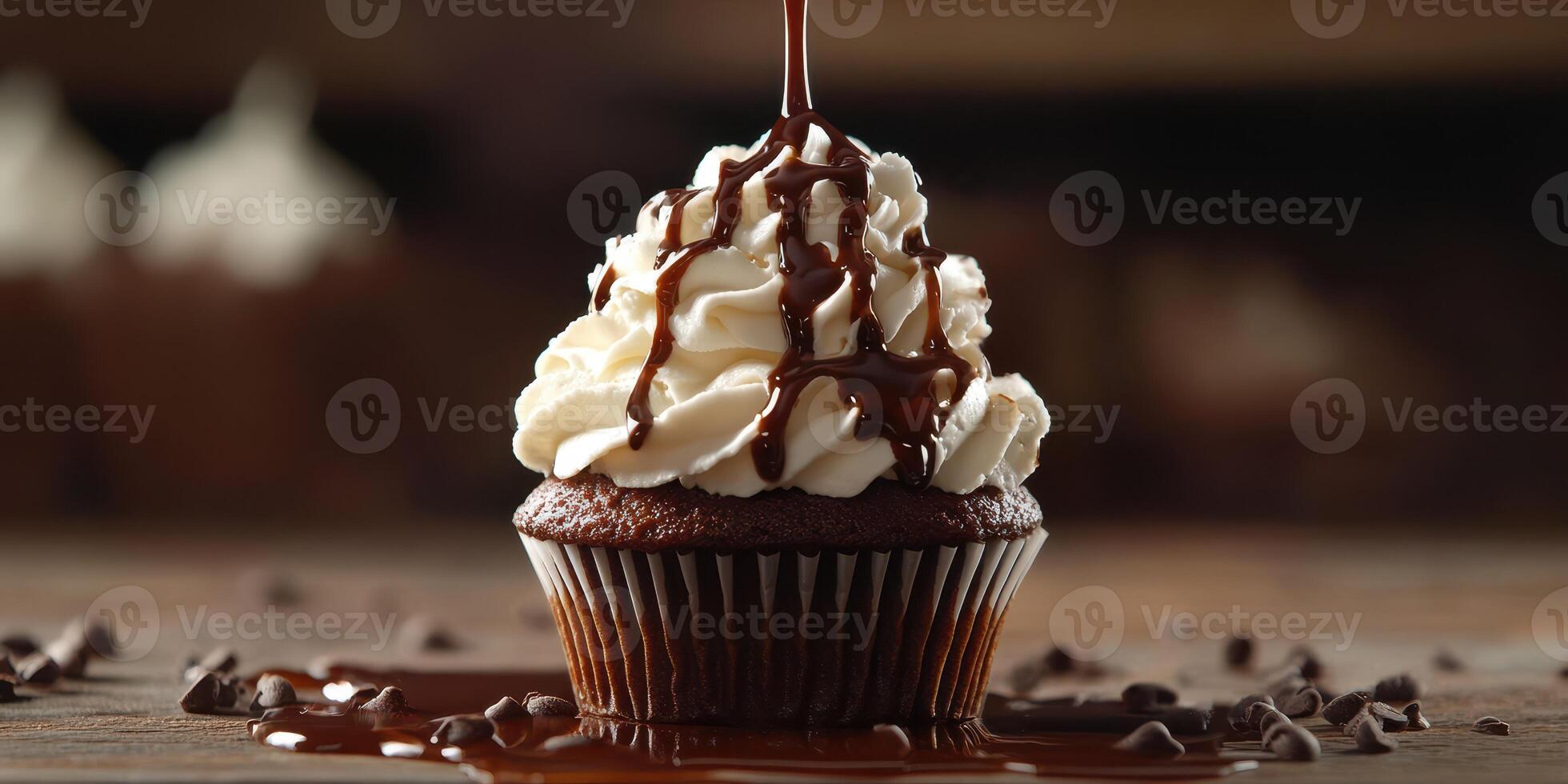 Chocolate cupcake topped with whipped cream and drizzled with chocolate sauce under soft lighting photo