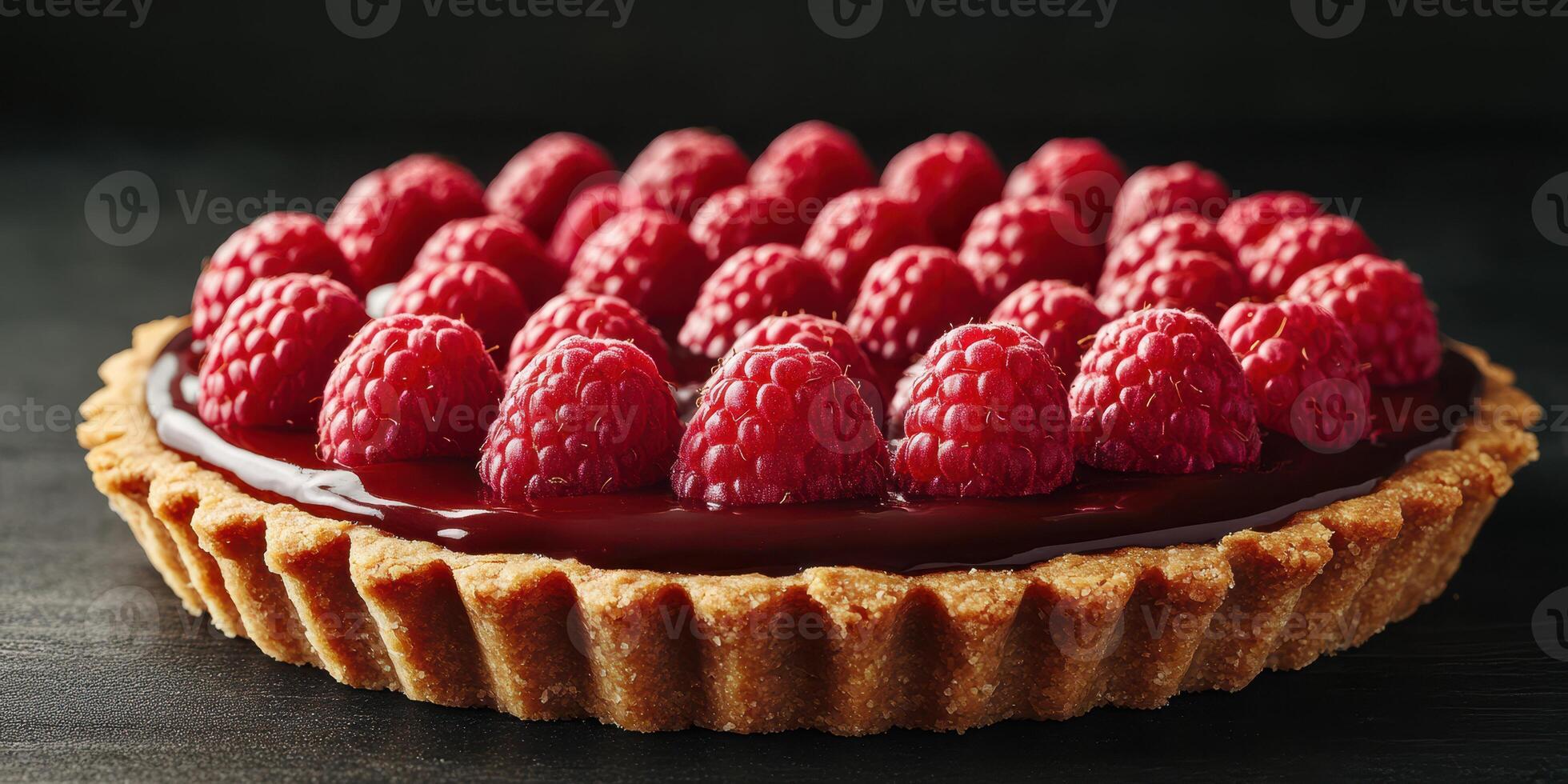 Delightful raspberry tart with a chocolate filling on a dark background showcasing fresh fruit photo