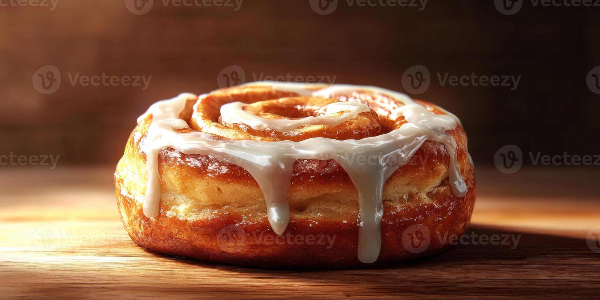 Freshly baked cinnamon roll with cream cheese icing resting on a wooden surface in warm light photo
