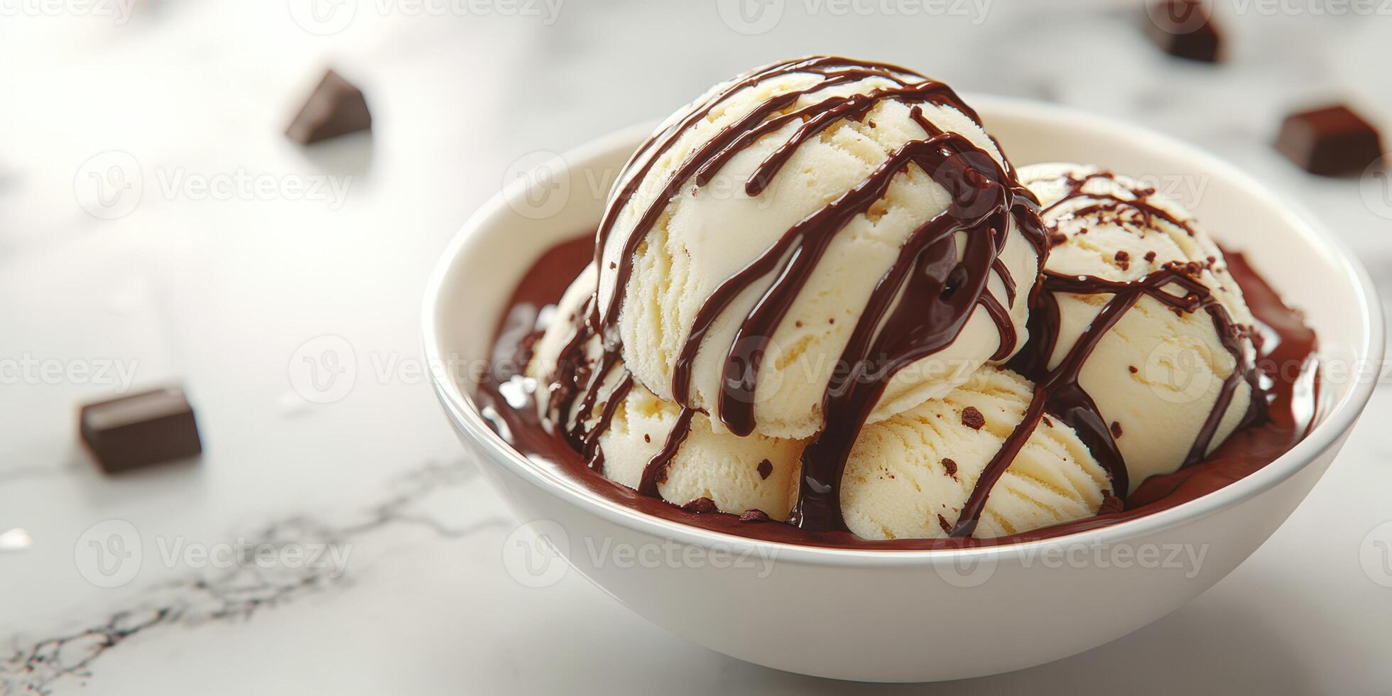 Delicious ice cream sundae with rich chocolate sauce served in a white bowl on a marble surface photo