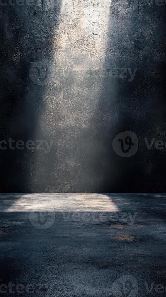 Moody light beams illuminate an empty dark room with textured walls and a concrete floor photo