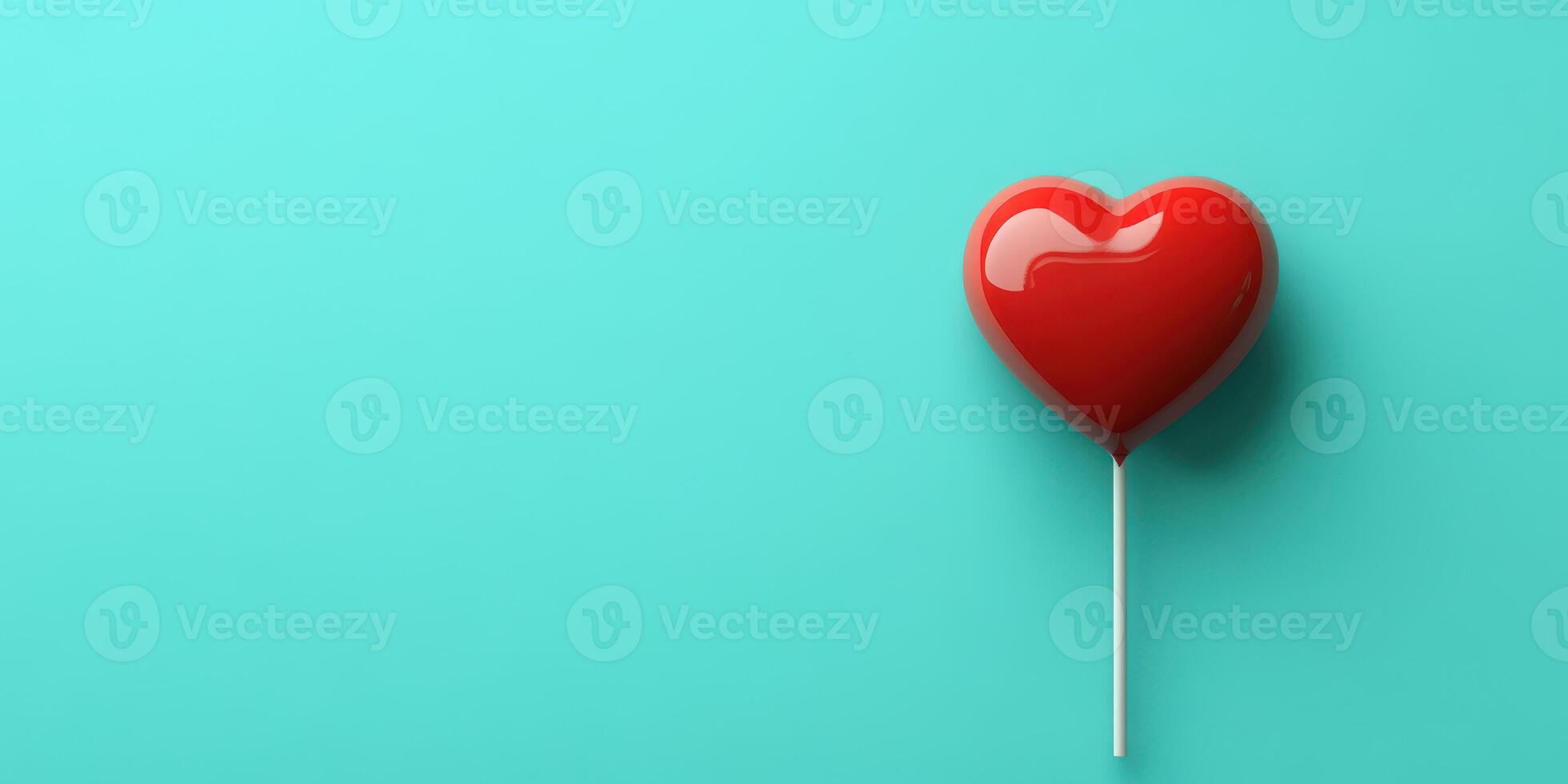 Red heart-shaped lollipop on a turquoise background showcasing a sweet treat perfect for celebrations or gifts photo