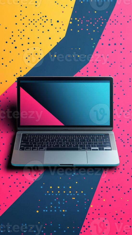 Laptop placed on vibrant geometric background featuring bold colors and patterns for creative workspace inspiration photo