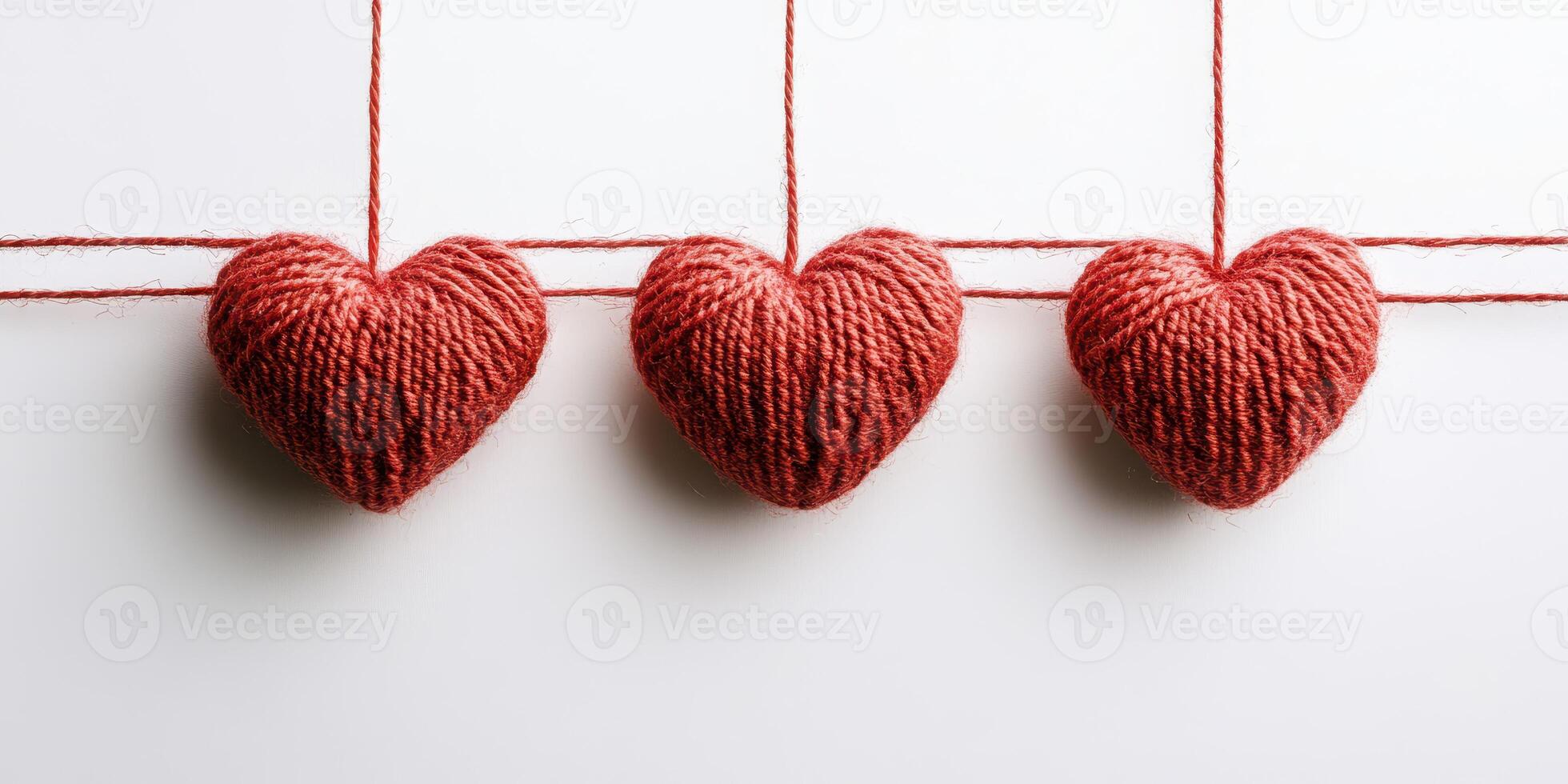 Handmade yarn hearts hanging on strings creating a cozy decoration in a bright space photo