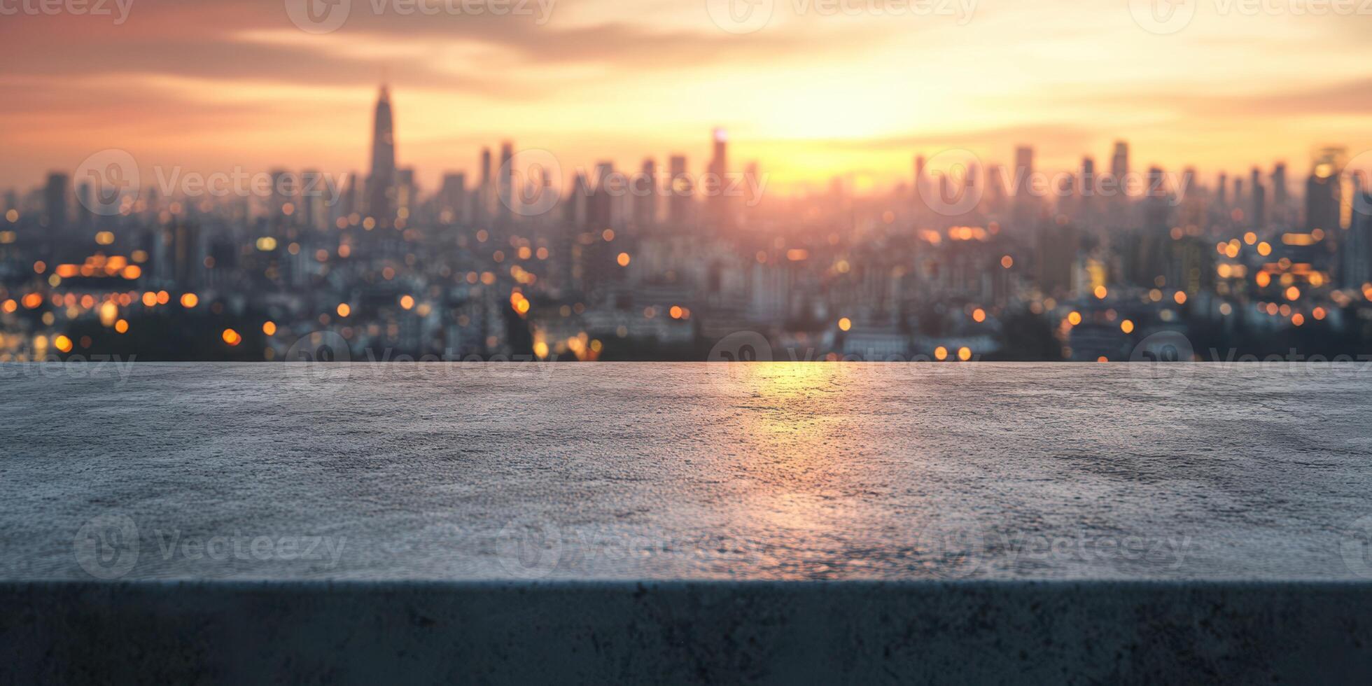 City skyline at sunset with illuminated buildings and a concrete ledge in the foreground photo