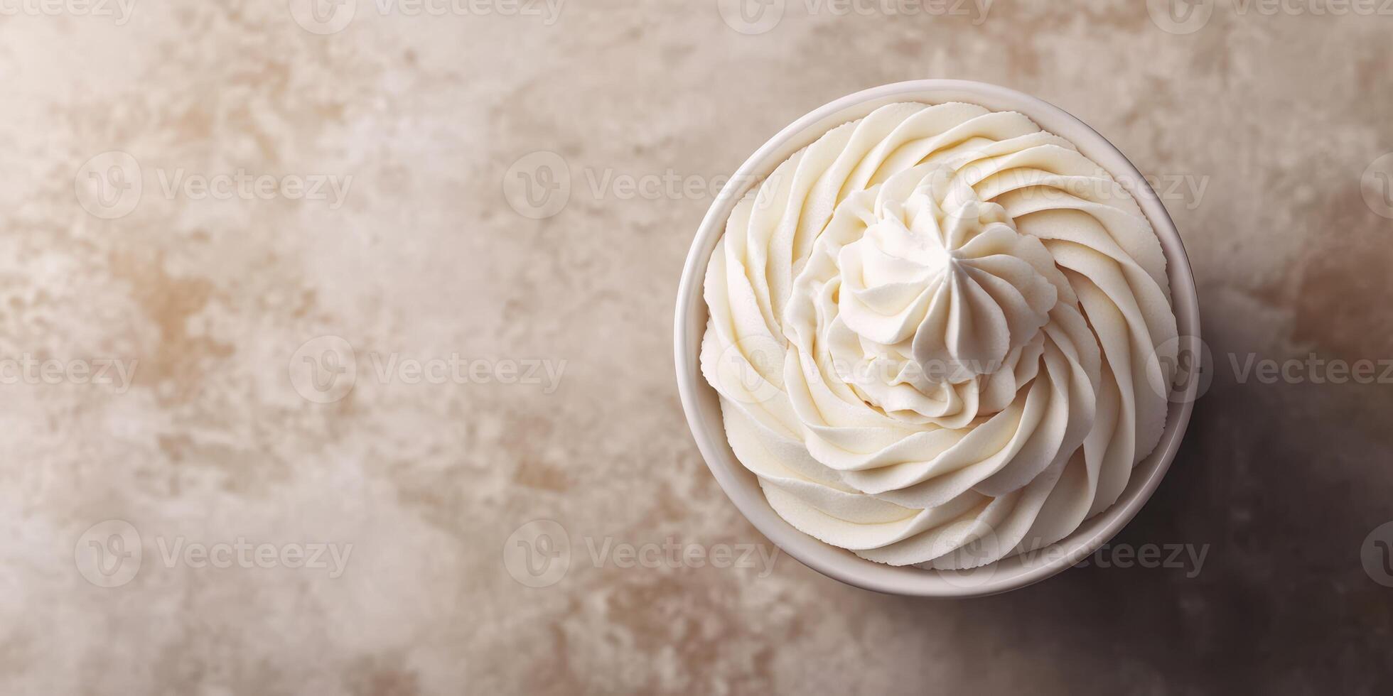 Swirls of whipped cream atop a dessert cup on a textured surface in a cozy setting photo