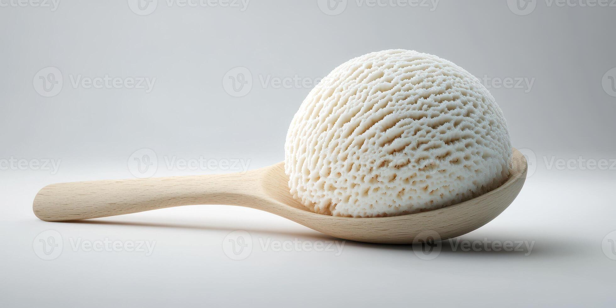 Creamy white ice cream sits on a wooden spoon against a simple background photo