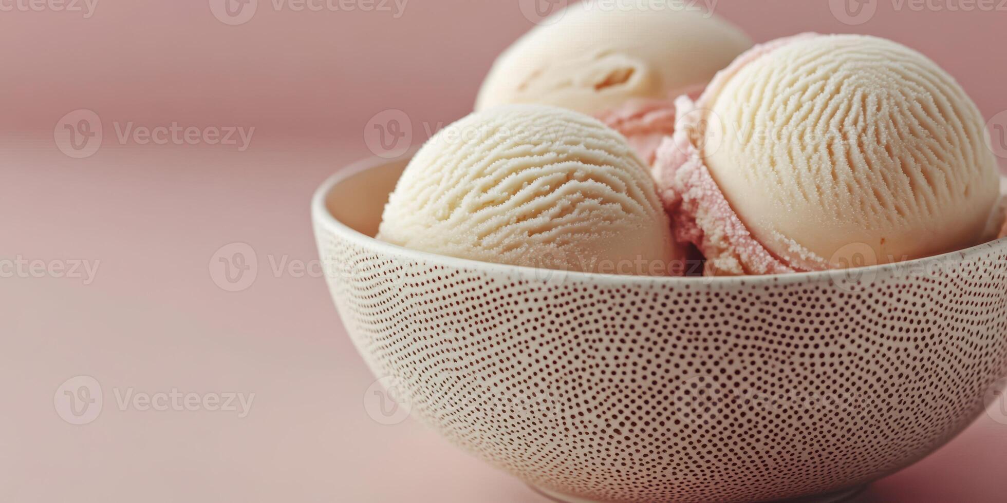 Delicious ice cream scoops served in a textured bowl against a soft pink backdrop photo