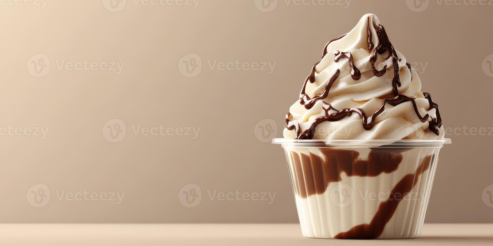 Soft serve ice cream topped with chocolate drizzle in a clear cup placed on a neutral background photo