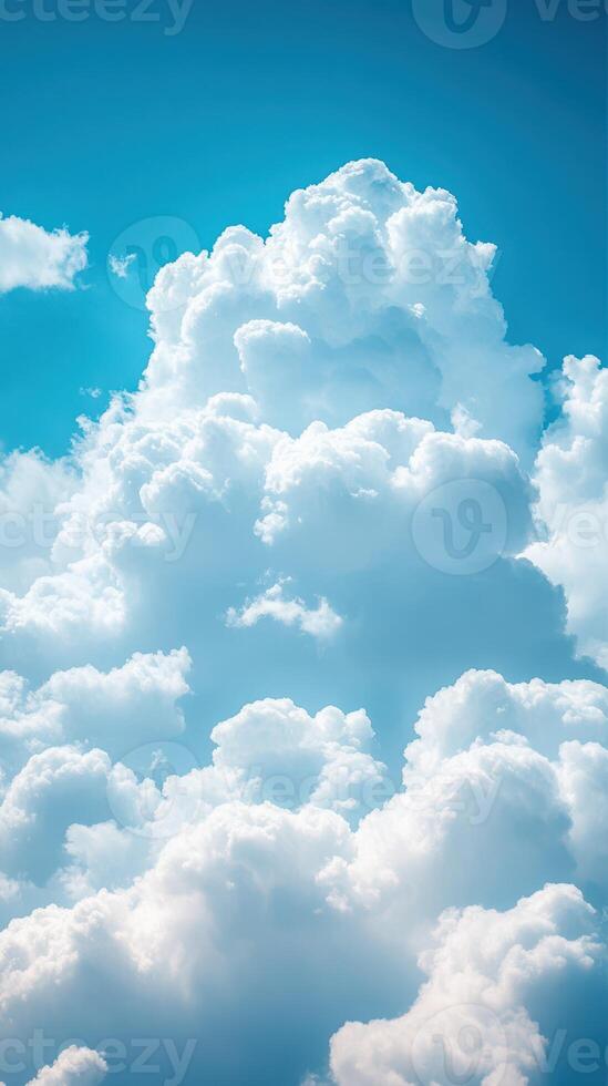 Bright fluffy clouds float against a clear blue sky in midday sunlight photo