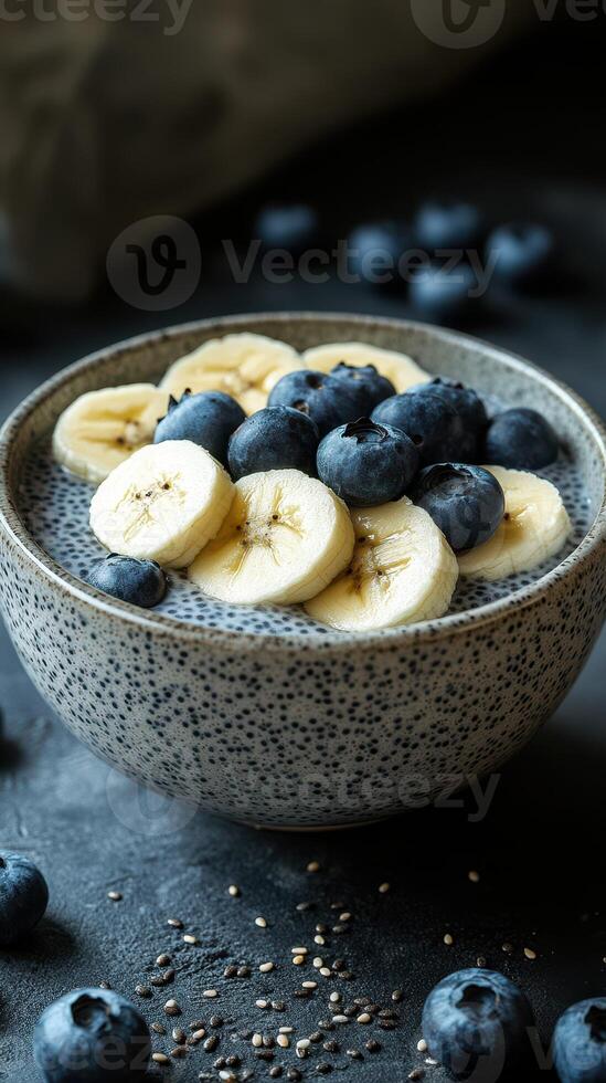 Healthy chia seed pudding topped with bananas and blueberries in a rustic bowl photo