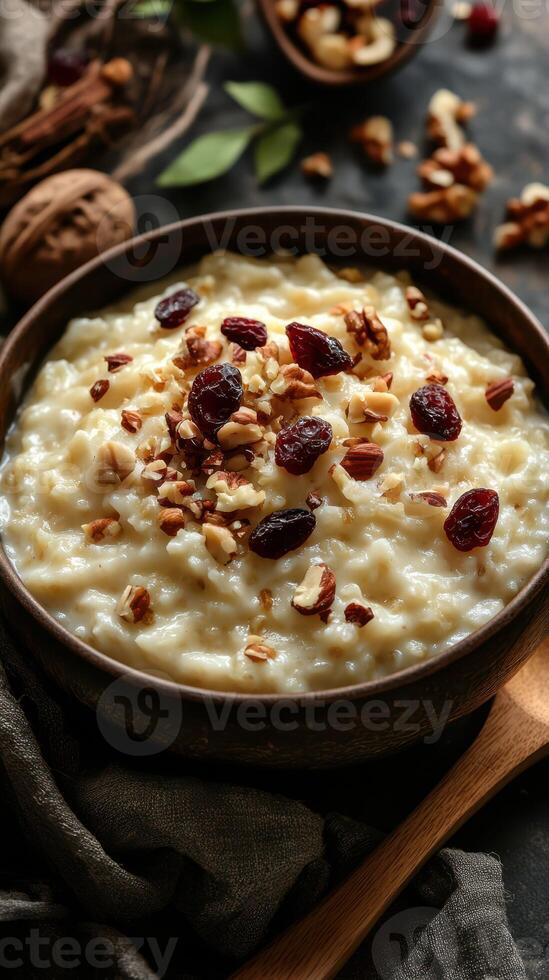 Creamy oatmeal topped with nuts and dried fruits served in a rustic bowl on a textured table photo