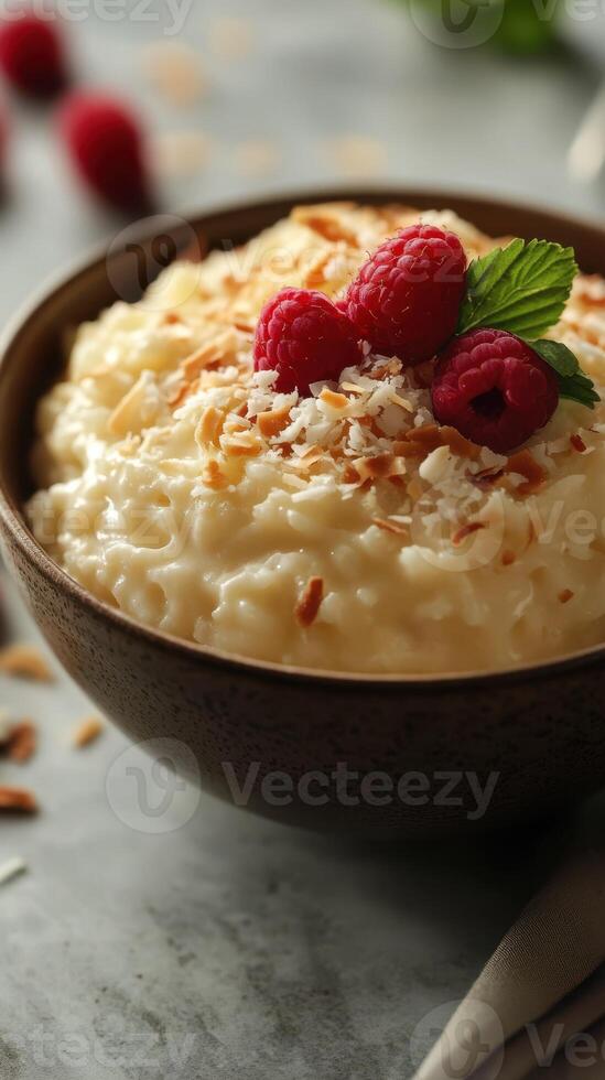 Creamy dessert with coconut and raspberries in a rustic bowl on a textured surface photo