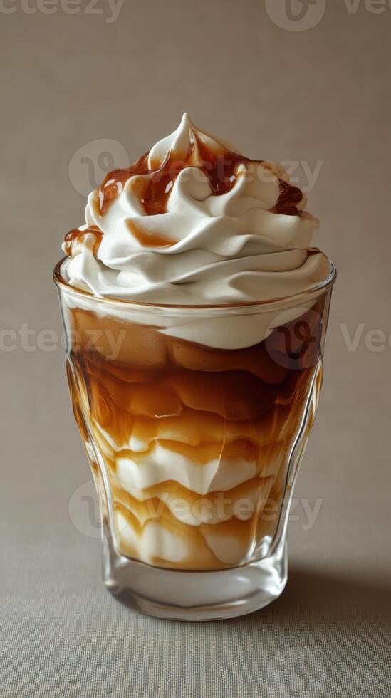 Whipped cream and caramel layered dessert in a glass served at a coffee shop in the afternoon photo
