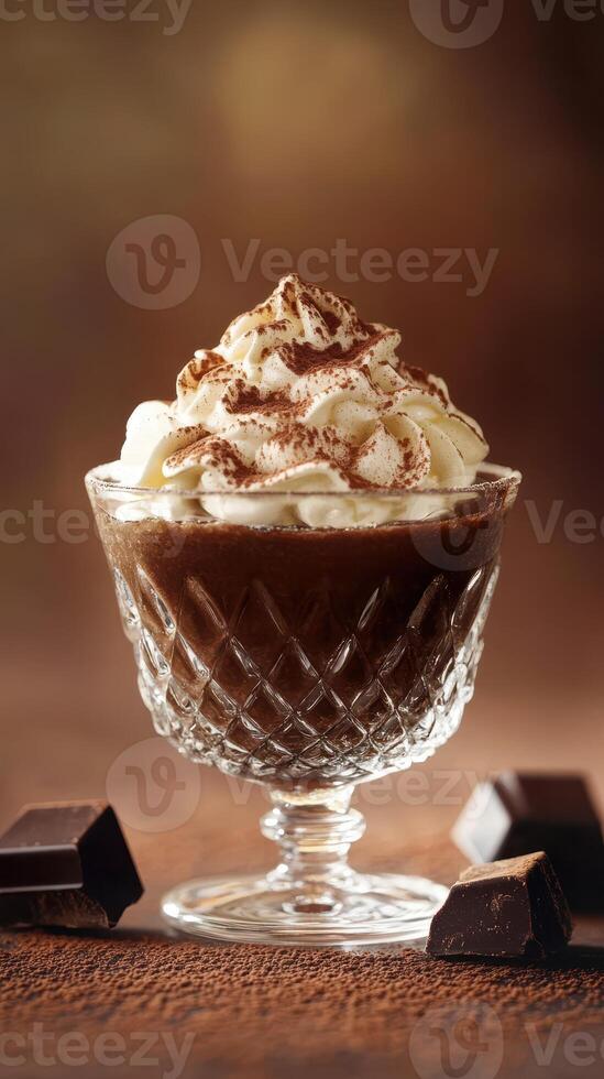 Creamy chocolate dessert topped with whipped cream and cocoa in a crystal cup on a textured background photo
