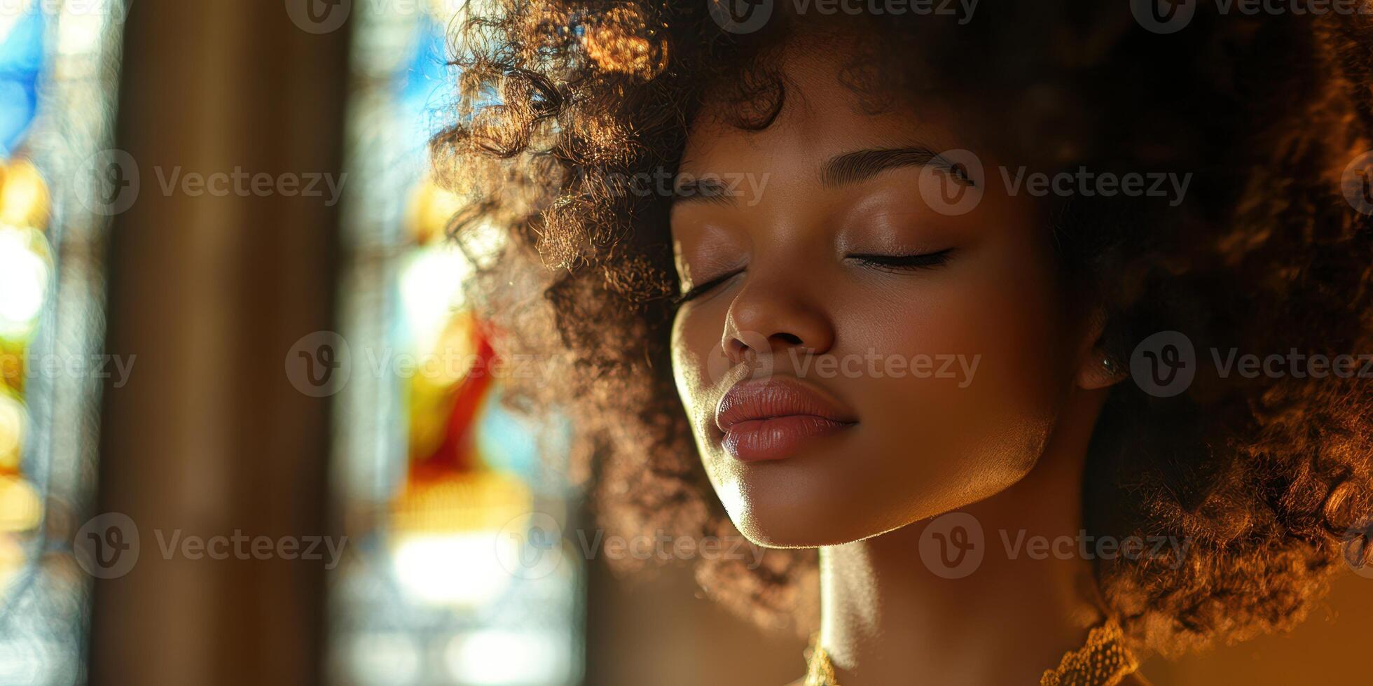 Young woman with curly hair meditating in a serene space with stained glass windows during golden hour photo