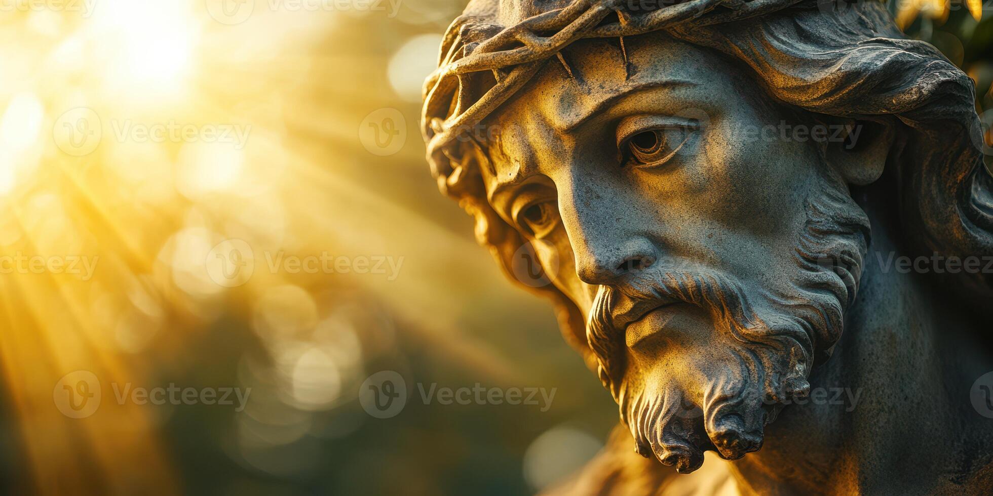 Statue of a religious figure with emotional expression under warm sunlight in a serene outdoor setting photo