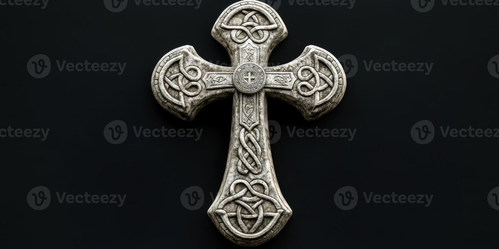 Intricate stone cross with Celtic designs displayed on a dark background photo