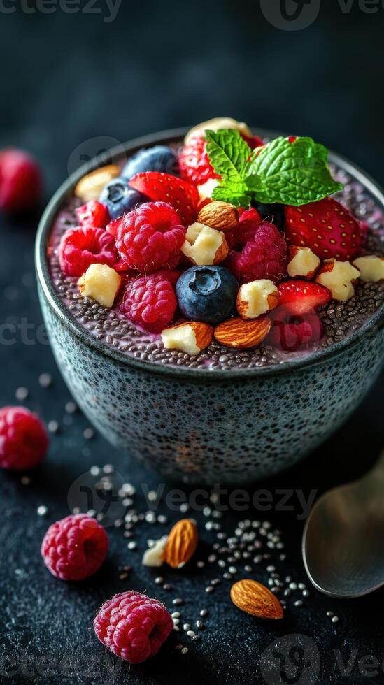 Chia seed pudding topped with fresh berries, nuts, and mint on a dark background photo