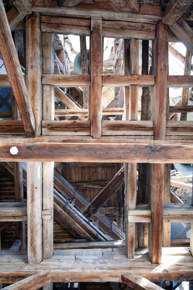 Bottom up view of old wooden beams in a medieval clock tower photo