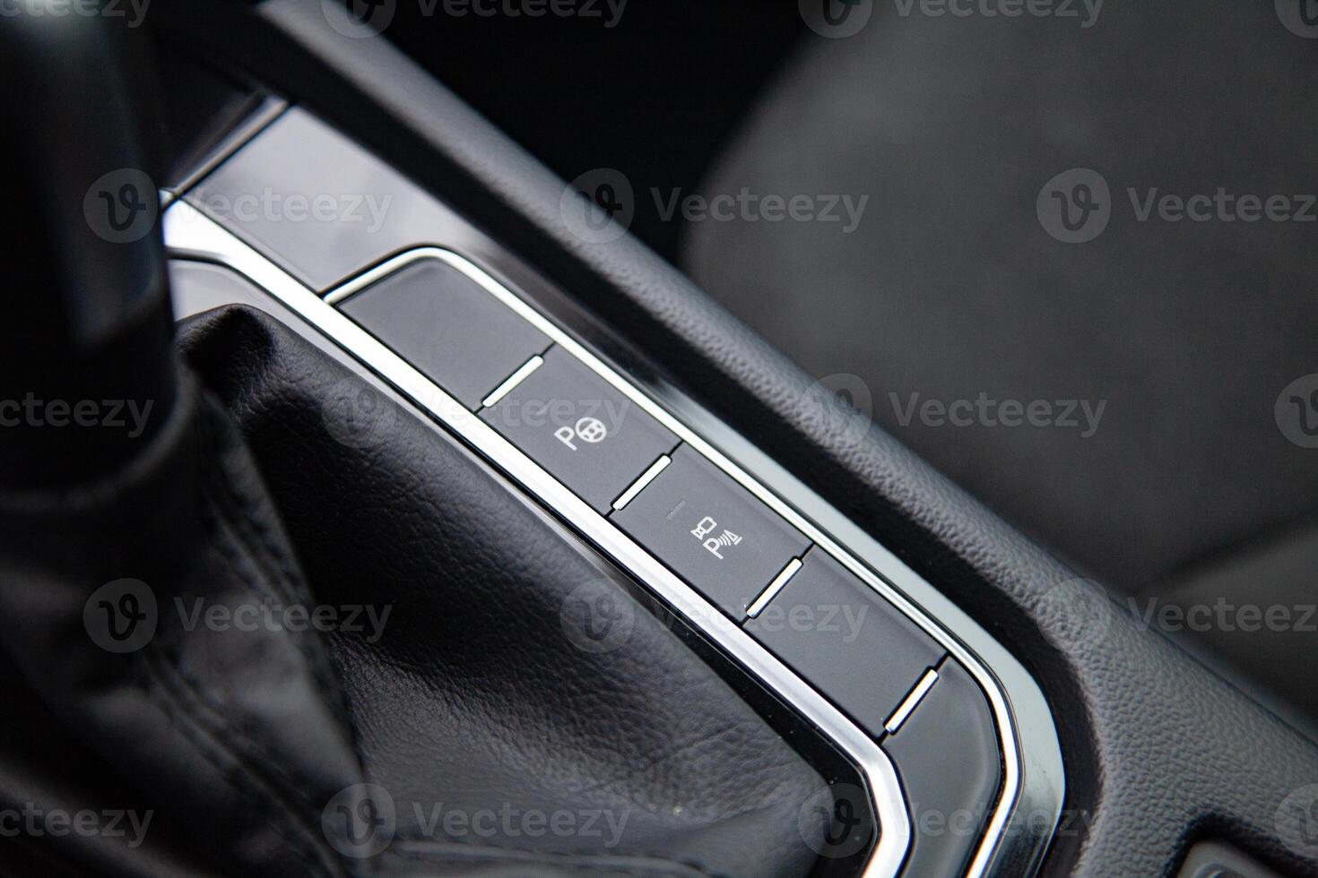 Buttons for activating the car's self-driving automatic autonomous parking function, parking assistant and parking sensors near the gear shift stick in a modern high-tech car photo