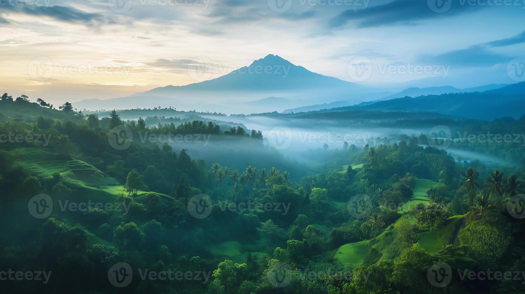 A mountain range with a foggy mist in the air. The mountains are covered in lush green trees photo