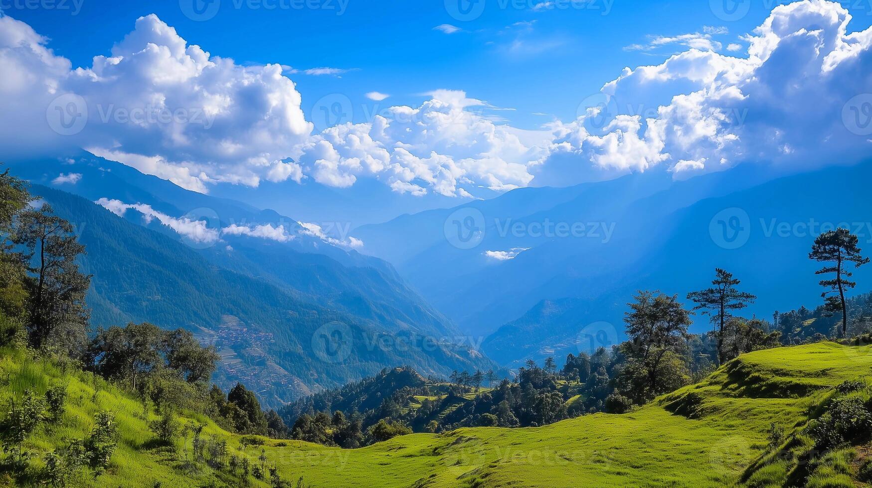 A beautiful mountain range with a clear blue sky. The mountains are covered in trees and the grass is lush and green. The scene is peaceful and serene photo