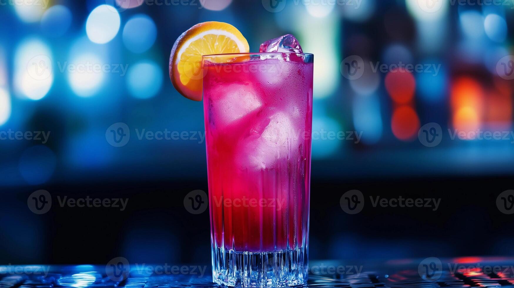 A glass of pink drink with an orange slice in it. The drink is served in a tall glass with ice cubes photo